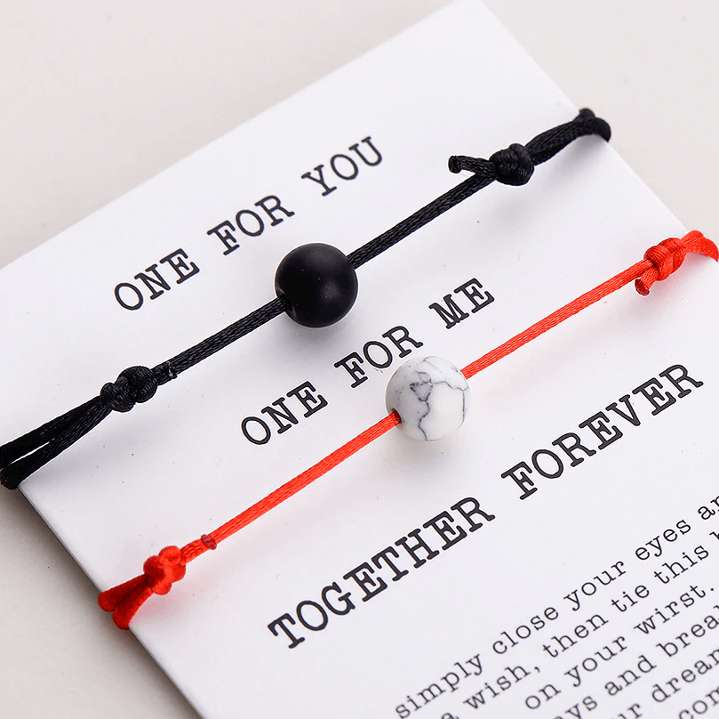 Gift card with red string and black string natural stone pair of bracelets