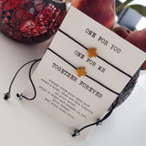pair of 2 black string bracelets with golden cross charm