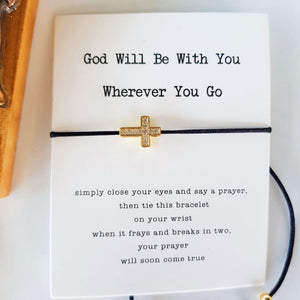 gold cross and black string bracelet