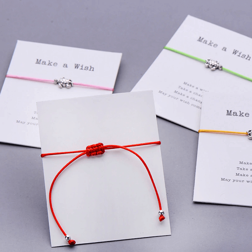back of the gift card with a red string bracelet on